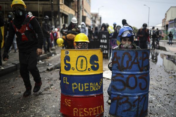 Manifestantes antigovernamentais se escondem atrás de escudos improvisados durante confrontos com a polícia, em Bogotá, na Colômbia, em 9 de junho de 2021 - Sputnik Brasil