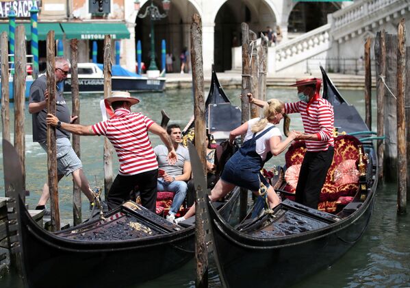 Gondoleiros ajudam turistas a entrar em gôndolas em Veneza, Itália, 7 de junho de 2021 - Sputnik Brasil