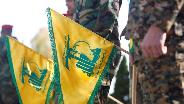 Membros do Hezbollah seguram bandeiras durante o Dia da Resistência e Libertação libanês no sul do Líbano, 25 de maio de 2021 - Sputnik Brasil
