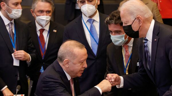 Presidente da Turquia, Recep Tayyip Erdogan (sentado), cumprimenta o presidente dos EUA, Joe Biden (de máscara preta), durante sessão plenária na cúpula da Organização do Tratado do Atlântico Norte (OTAN), em Bruxelas, na Bélgica, em 14 de junho de 2021 - Sputnik Brasil
