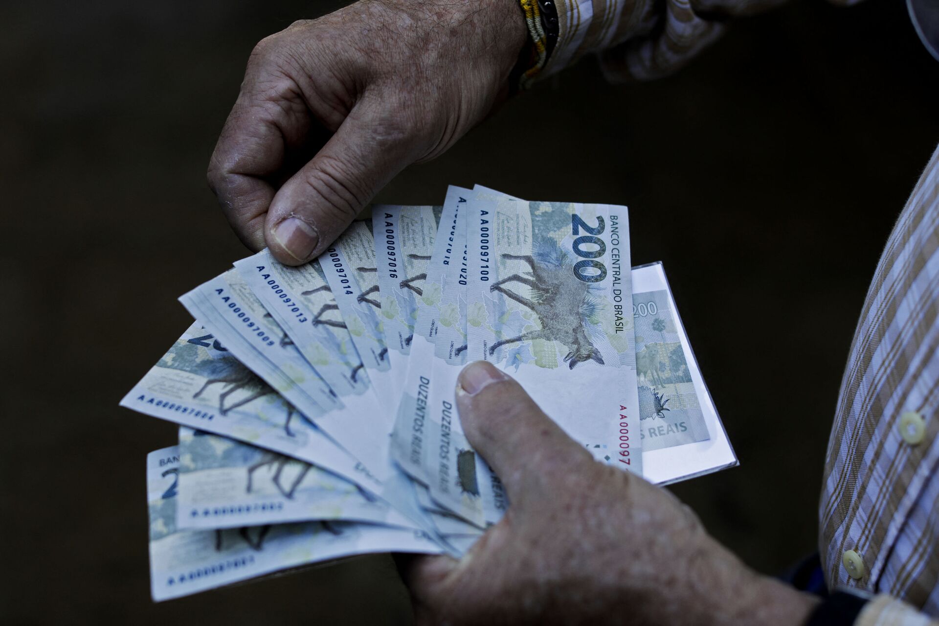 Homem segura notas de 200 reais, 2 de setembro de 2020 - Sputnik Brasil, 1920, 31.01.2023