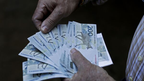 Homem segura notas de 200 reais, 2 de setembro de 2020 - Sputnik Brasil