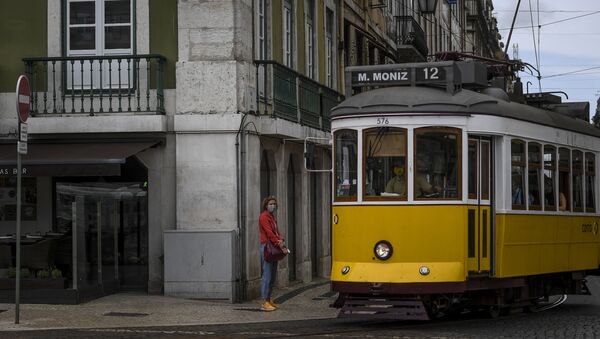 Elétrico passa por uma mulher com máscara na Baixa de Lisboa - Sputnik Brasil