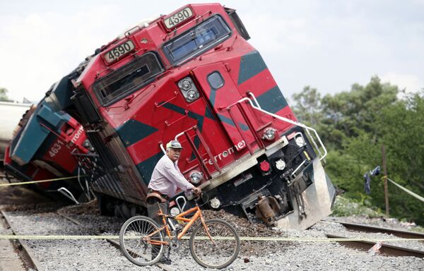Homem com bicicleta passa junto de trem que descarrilou em Tala, estado de Jalisco, México, 15 de junho de 2021 - Sputnik Brasil