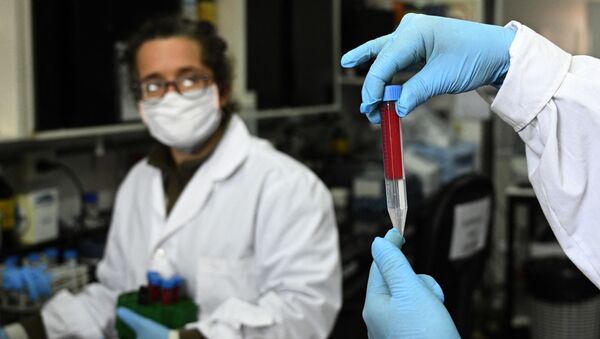 Pesquisadora Viviana Parreno segura uma amostra de sangue ao lado da também pesquisadora Gisela Marcoppido em Buenos Aires, Argentina. Foto de arquivo - Sputnik Brasil