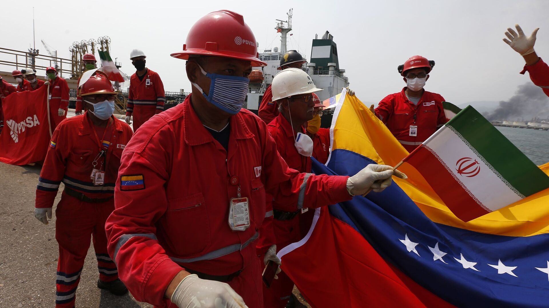 Trabalhador petrolífero da Venezuela com pequena bandeira do Irã participa de cerimônia de chegada do petroleiro iraniano Fortune na refinaria El Palito, perto de Puerto Cabello, Venezuela, 25 de maio de 2020 - Sputnik Brasil, 1920, 24.06.2021