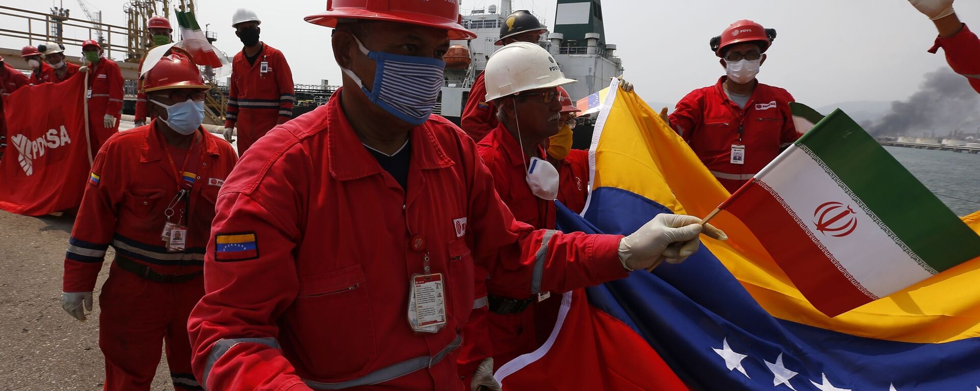 Trabalhador petrolífero da Venezuela com pequena bandeira do Irã participa de cerimônia de chegada do petroleiro iraniano Fortune na refinaria El Palito, perto de Puerto Cabello, Venezuela, 25 de maio de 2020 - Sputnik Brasil, 1920, 24.06.2021