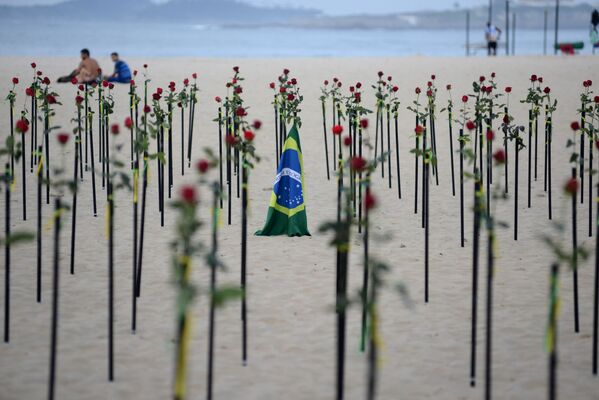 Bandeira do Brasil em meio a flores vermelhas colocadas pela ONG Rio de Paz na praia de Copacabana para homenagear a morte de 500.000 pessoas pela COVID-19 no Rio de Janeiro, Brasil, 20 de junho de 2021 - Sputnik Brasil