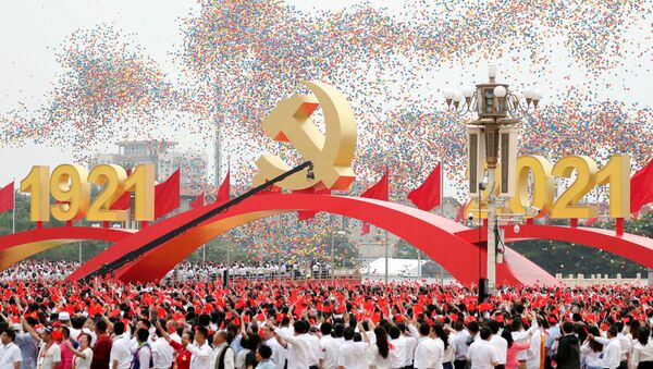 Participantes com bandeiras nacionais saúdam libertação de balões no fim do evento marcando o centenário da fundação do Partido Comunista da China, Pequim, China, 1º de julho de 2021 - Sputnik Brasil