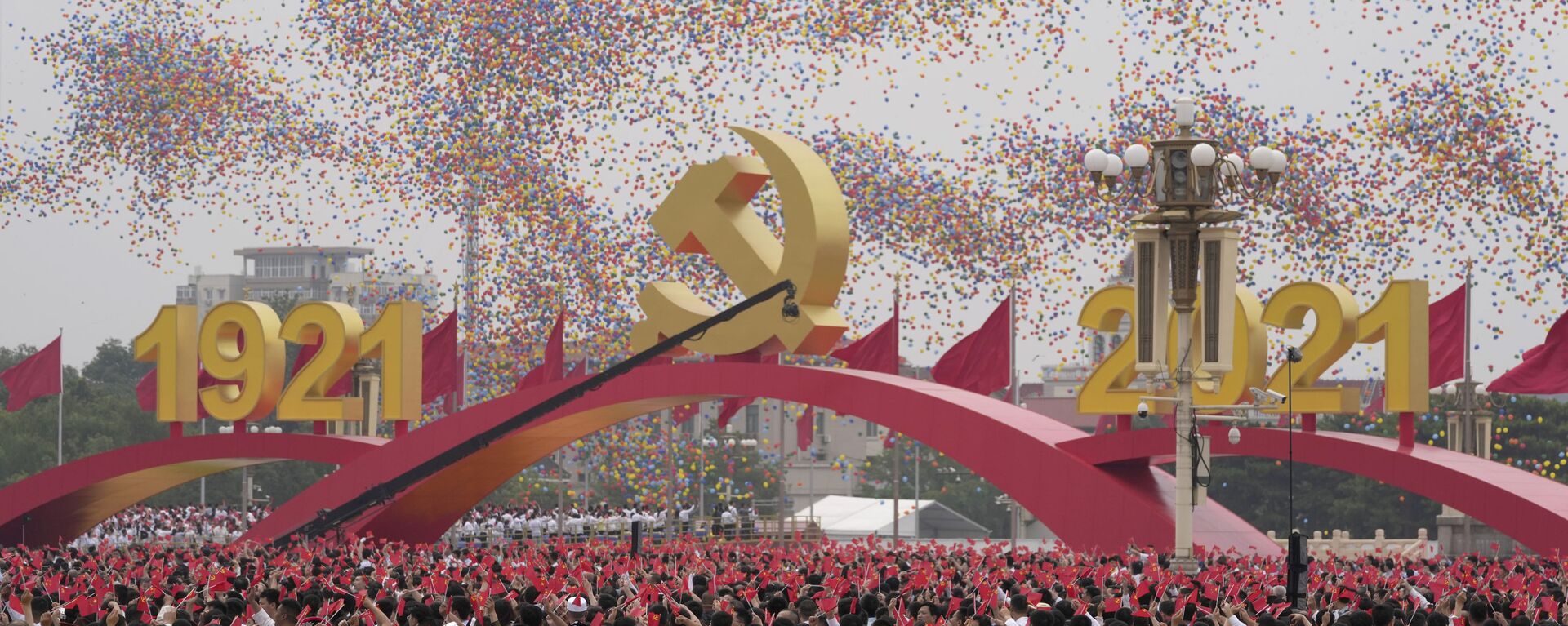 Balões colorem o céu enquanto participantes agitam bandeirolas chinesas durante o 100º aniversário de fundação do Partido Comunista da China (PCC), na praça Tiananmen, em Pequim - Sputnik Brasil, 1920, 09.11.2022