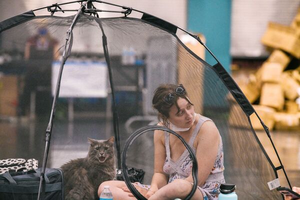 Mulher e seu gato descansam dentro de uma tenda na estação de resfriamento em Oregon, EUA, 28 de junho de 2021 - Sputnik Brasil