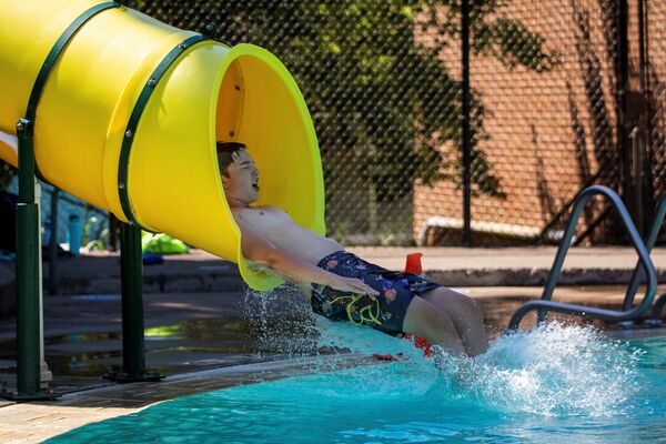 Menino no escorrega d'água na piscina pública durante calor anormal em Portland, EUA, 27 de junho de 2021 - Sputnik Brasil