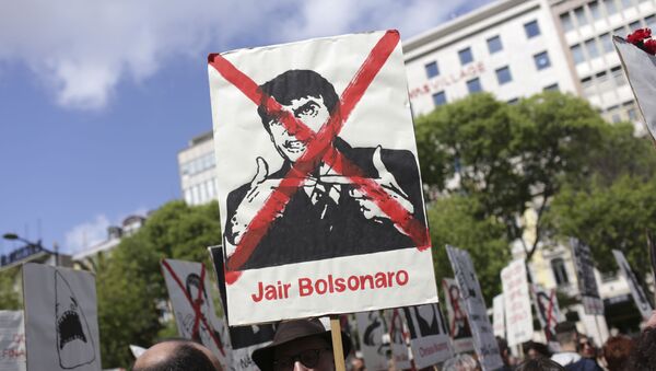 Manifestante segura cartaz contra Bolsonaro no Desfile de 25 de Abril, em 2019, em Lisboa - Sputnik Brasil