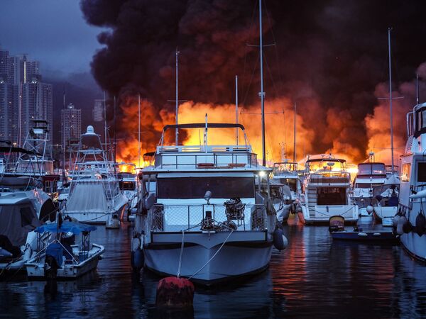 Chamas e fumaça sobem no ar em meio a incêndio que atingiu o abrigo de tufões de Aberdeen, levando à destruição de mais de 12 embarcações e à hospitalização de uma pessoa, na manhã de de 27 de junho de 2021, em Hong Kong, China - Sputnik Brasil