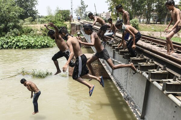 Jovens saltam em canal para se refrescar durante dia quente de verão na periferia de Amritsar, Índia, 27 de junho de 2021 - Sputnik Brasil