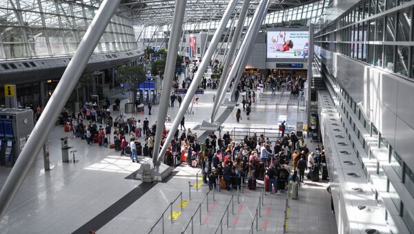 Viajantes com máscaras faciais fazem fila nos balcões de check-in no aeroporto de Dusseldorf, Alemanha, 2 de julho de 2021 - Sputnik Brasil
