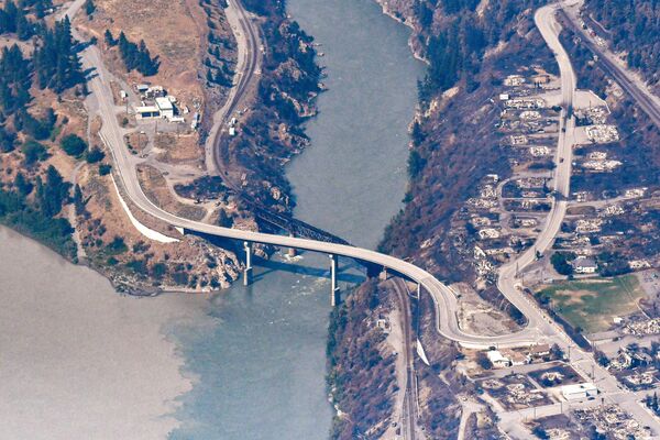 Ponte ferroviária danificada e restos queimados de casas e prédios destruídos pelo incêndio na vila de Lytton, Canadá, vista aérea capturada em 6 de julho de 2021 - Sputnik Brasil