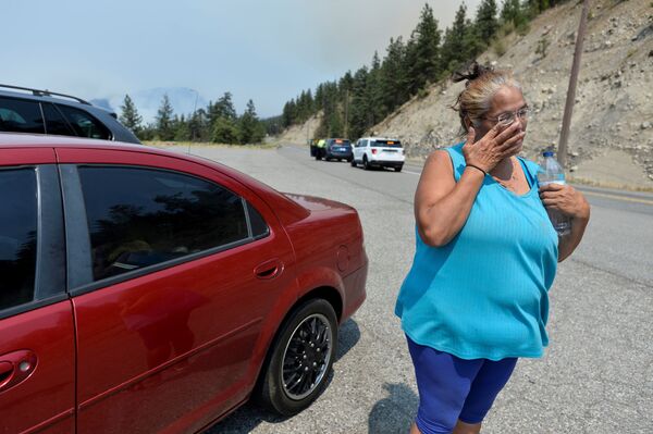 Mulher residente na vila de Lytton ao lado de seu carro após o incêndio ter atingido a vila, forçando seus moradores a abandonar suas casas, Canadá, 1º de julho de 2021 - Sputnik Brasil