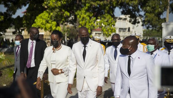Presidente haitiano Jovenel Moïse (ao centro), caminha com a primeira-dama Martine Moïse (esquerda) e com o primeiro-ministro interino Claude Joseph (direita) durante cerimônia que marcou o 218º aniversário da criação da bandeira haitiana. Foto de arquivo - Sputnik Brasil