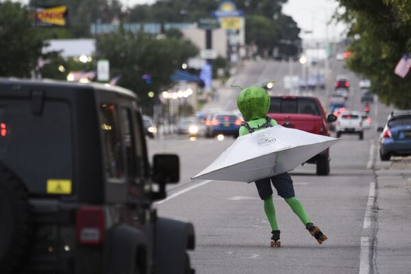 Homem em traje alienígena em disco voador patinando na rua durante o festival de OVNIs em Roswell, Novo México, EUA - Sputnik Brasil