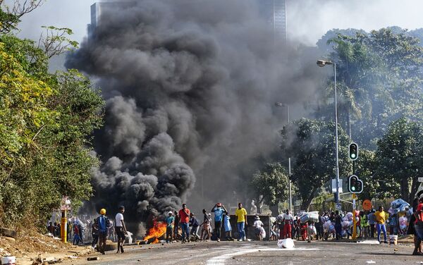 Manifestantes no exterior de centro comercial e perto de barricada em chamas em Durban, África do Sul, 12 de julho de 2021 - Sputnik Brasil