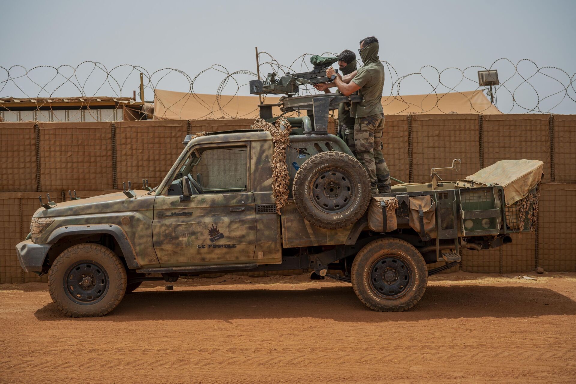 Soldados da força francesa da operação Barkhane montam uma metralhadora em uma picape camuflada enquanto trabalhadores do Mali passam antes de partir em uma missão de sua base em Gao, Mali, 7 de junho de 2021 - Sputnik Brasil, 1920, 02.12.2021