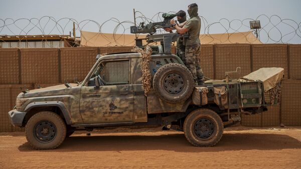 Soldados da força francesa da operação Barkhane montam uma metralhadora em uma picape camuflada enquanto trabalhadores do Mali passam antes de partir em uma missão de sua base em Gao, Mali, 7 de junho de 2021 - Sputnik Brasil