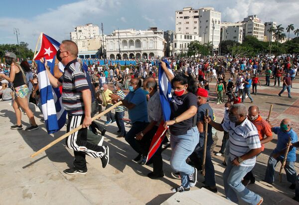 Apoiadores do governo caminham durante protestos contra e em apoio ao governo, em meio ao surto da COVID-19, em Havana, no domingo (11) - Sputnik Brasil