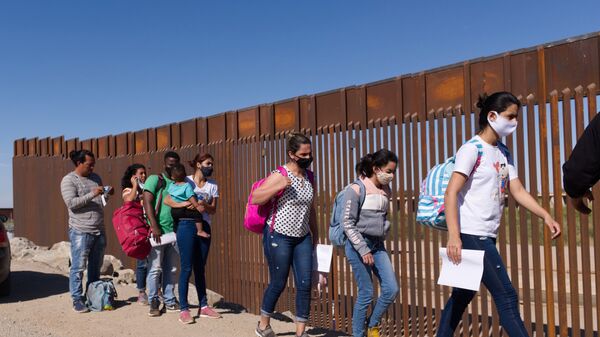 Um grupo de migrantes brasileiros contorna uma lacuna na fronteira dos EUA com o México em Yuma, Arizona, buscando asilo nos Estados Unidos após cruzar o território do México, 8 de junho de 2021 - Sputnik Brasil