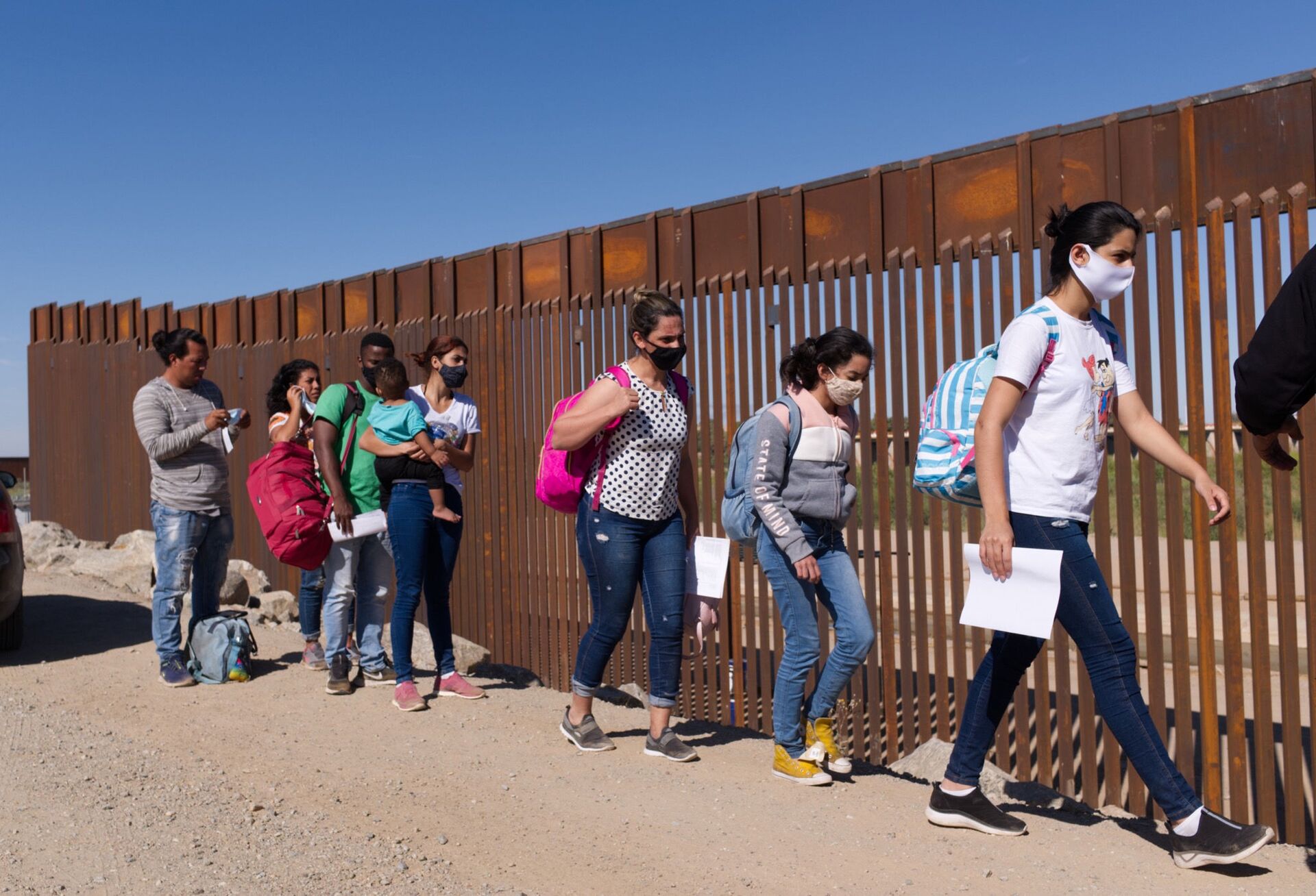 Um grupo de migrantes brasileiros contorna uma lacuna na fronteira dos EUA com o México em Yuma, Arizona, buscando asilo nos Estados Unidos após cruzar o território do México, 8 de junho de 2021 - Sputnik Brasil, 1920, 17.12.2021