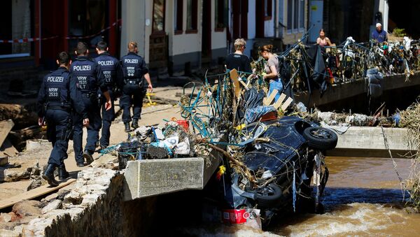 Police officers walk by a damaged car in an area affected by floods caused by heavy rainfalls in Bad Muenstereifel, Germany, July 18, 2021. - Sputnik Brasil