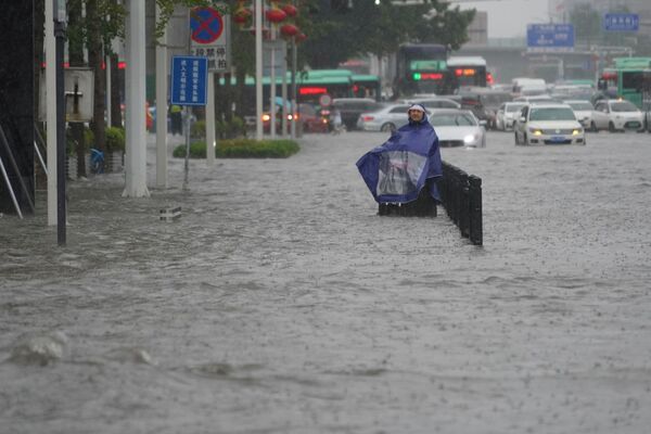 Mulher usando capa de chuva em estrada inundada na cidade de Zhengzhou, China, 20 de julho de 2021 - Sputnik Brasil