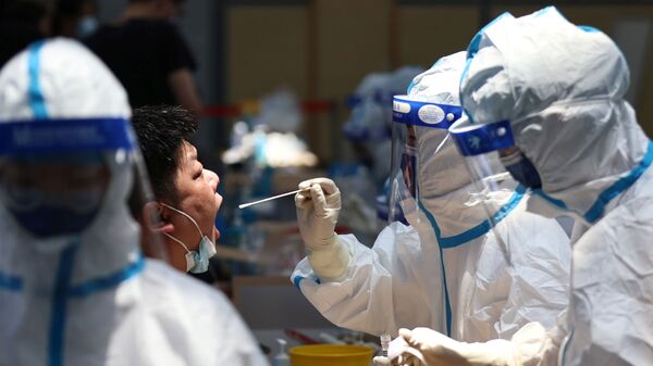 Funcionário da saúde em traje de proteção realiza teste à COVID-19 em Nanjing, China, 21 de julho de 2021 - Sputnik Brasil