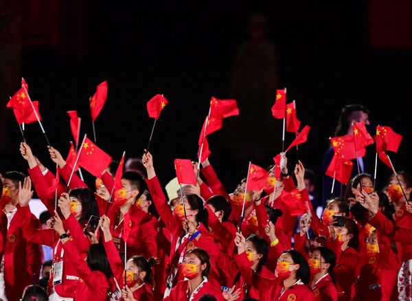 Atletas da delegação da China agitam bandeiras ao entrar no Estádio Olímpico durante a cerimônia de abertura dos Jogos Olímpicos de Tóquio 2020 - Sputnik Brasil