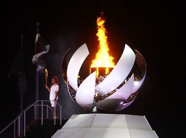 Naomi Osaka, do Japão, segura a tocha olímpica após acender a pira olímpica na cerimônia de abertura - Sputnik Brasil