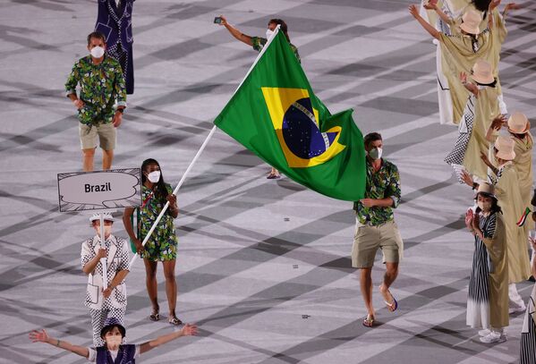 Os atletas brasileiros Ketleyn Quadros e Renato Rezende levam a bandeira do país durante o desfile de atletas na cerimônia de abertura dos Jogos de Tóquio 2020, nesta sexta-feira (23) - Sputnik Brasil