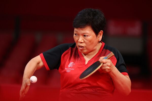 Tenista de mesa Xia Lian Ni de Luxemburgo, de 58 anos, em ação durante partida de mulheres contra Shin Yubin, da Coreia do Sul (fora da foto) no Ginásio Metropolitano de Tóquio, Tóquio, Japão, 25 de julho de 2021 - Sputnik Brasil