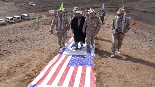 Membros do IRGC e um clérigo caminham sobre representações de bandeiras de Israel e EUA - Sputnik Brasil