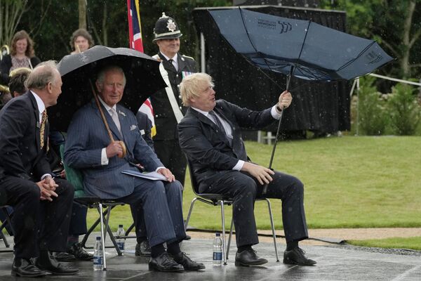Charles, príncipe de Gales, e o primeiro-ministro britânico, Boris Johnson, se abrigam de chuva em Alrewas, Reino Unido, 28 de julho de 2021
 - Sputnik Brasil