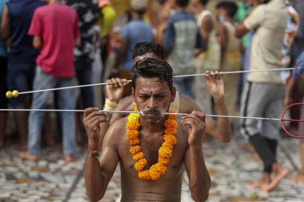 Fiéis com tridente de aço perfurando suas faces como parte de um ritual,  no templo da deusa hindu Sheetla Mata em Jammu, Índia, 25 de julho de 2021 - Sputnik Brasil