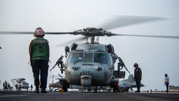Marinheiros preparam helicóptero MH-60S Sea Hawk, do Esquadrão de Combate Marítimo de Helicópteros (HSC) 12, para iniciar voo do convés do porta-aviões USS Ronald Reagan em resposta a um pedido de assistência do navio Mercer Street no mar Arábico - Sputnik Brasil