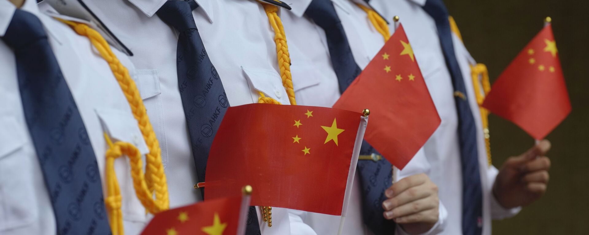Os alunos seguram as bandeiras nacionais chinesas durante uma cerimônia de hasteamento da bandeira para marcar o 24º aniversário da transferência de Hong Kong para a China, 1º de julho de 2021 - Sputnik Brasil, 1920, 10.08.2021