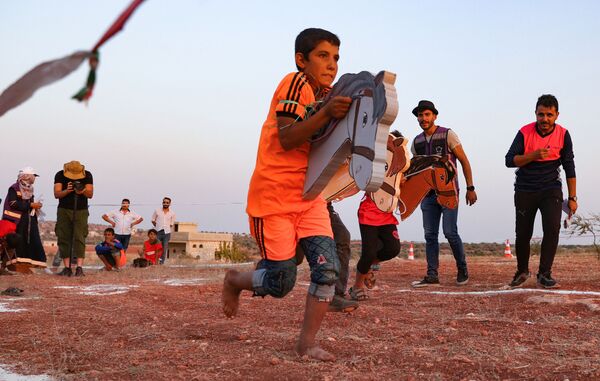Crianças refugiadas sírias brincam durante os Campos Olímpicos 2020 na cidade de Foua, o último grande bastião rebelde da região de Idlib, 7 de agosto de 2021 - Sputnik Brasil