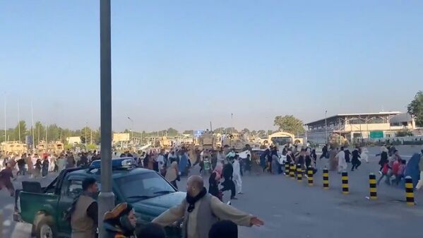 Pessoas correm rumo ao terminal do Aeroporto de Cabul, após os talibãs terem tomado controle sobre o palácio presidencial afegão, 16 de agosto de 2021 - Sputnik Brasil