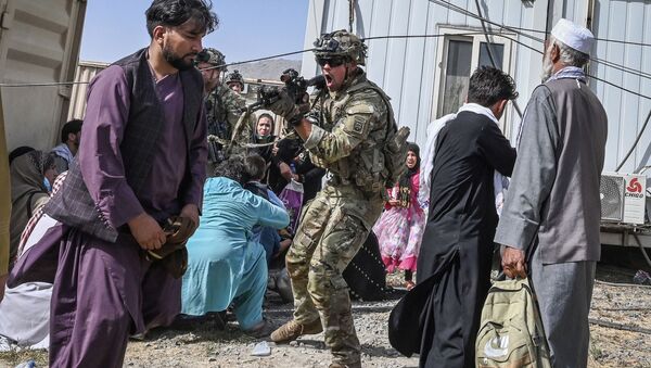 Soldado dos EUA aponta sua arma contra um passageiro afegão no aeroporto de Cabul, Afeganistão, 16 de agosto de 2021
 - Sputnik Brasil