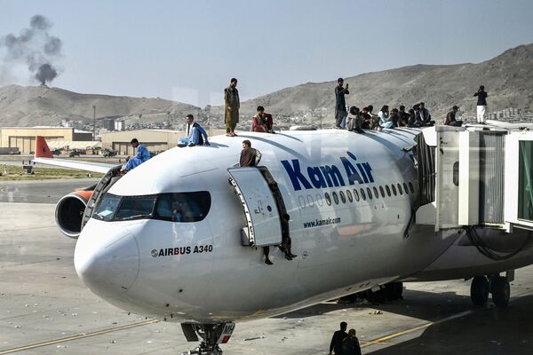 Afegãos sobem ao topo de um avião no aeroporto de Cabul, Afeganistão, 16 de agosto de 2021 - Sputnik Brasil