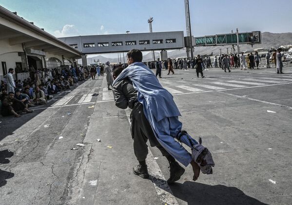 Voluntário carrega um afegão ferido no aeroporto de Cabul, Afeganistão, 16 de agosto de 2021 - Sputnik Brasil