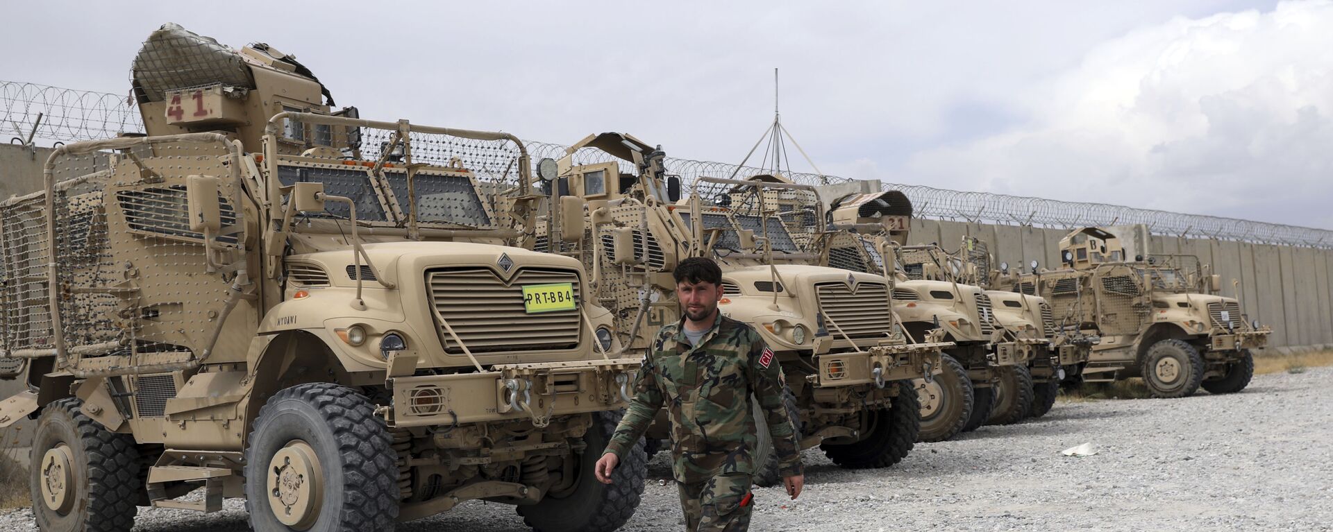 Soldado afegão passa por veículos MRAP (protegidos contra emboscadas e resistentes a minas) que os EUA deixaram na base aérea de Bagram, Afeganistão, 5 de julho de 2021 - Sputnik Brasil, 1920, 06.10.2021