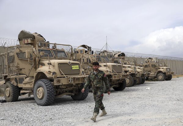 Soldado afegão passa por veículos MRAP (protegidos contra emboscadas e resistentes a minas) que os EUA deixaram na base aérea de Bagram, Afeganistão, 5 de julho de 2021 - Sputnik Brasil