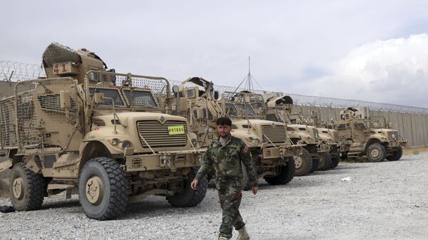 Soldado afegão passa por veículos MRAP (protegidos contra emboscadas e resistentes a minas) que os EUA deixaram na base aérea de Bagram, Afeganistão, 5 de julho de 2021 - Sputnik Brasil